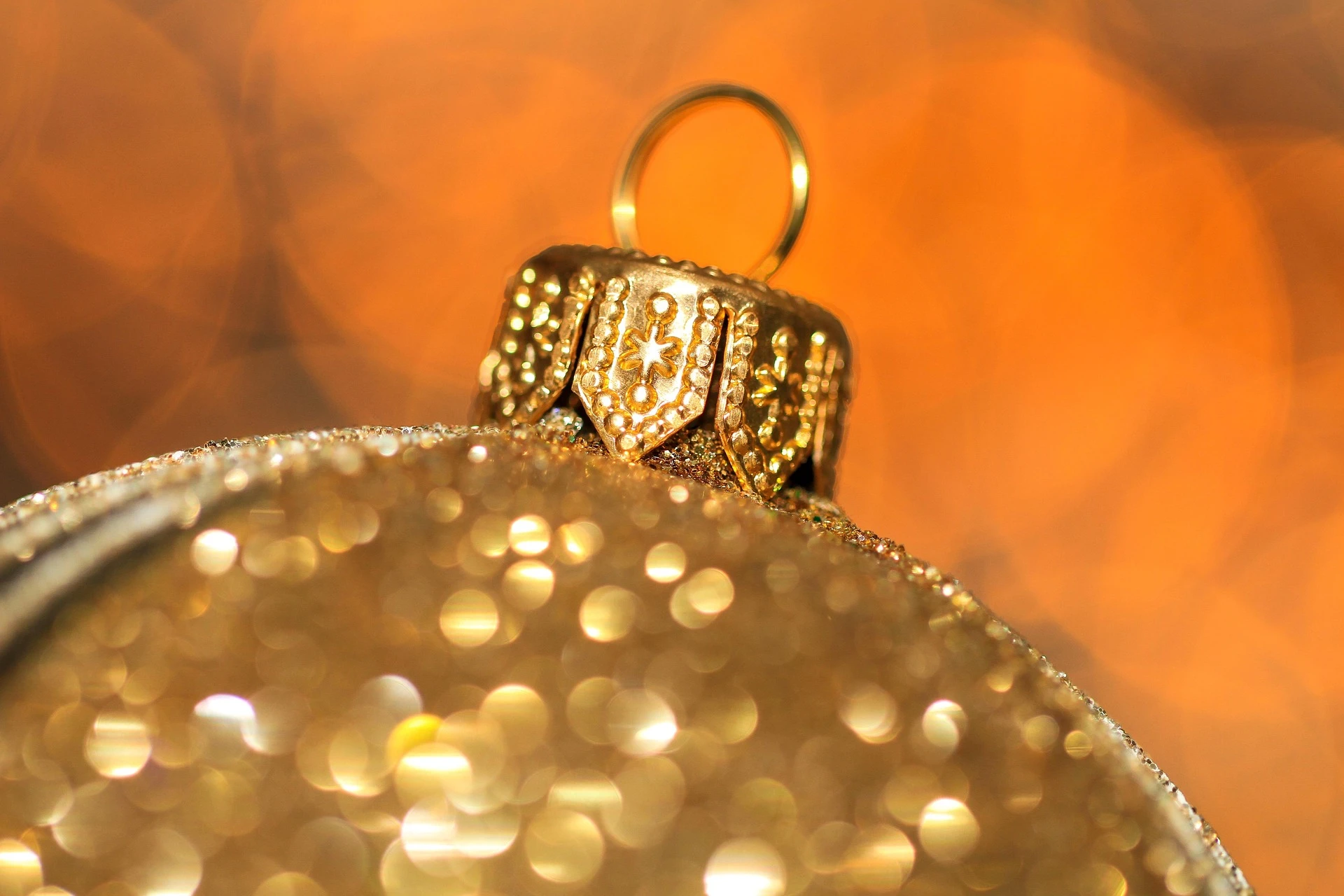 Boule dorée de Noël suspendue au sapin, reflétant les lumières festives et apportant une touche d’élégance et de chaleur aux décorations. Photo publiée sur monsieurdefrance.com.