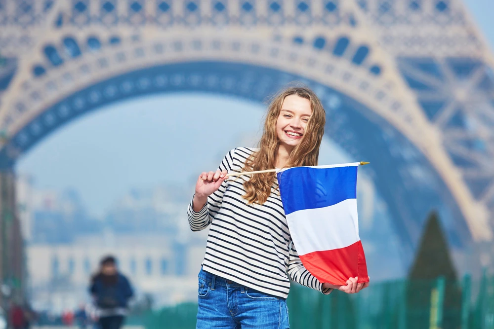 young girl holding the French flag in France symbol of French culture identity and traditional French names inspiration