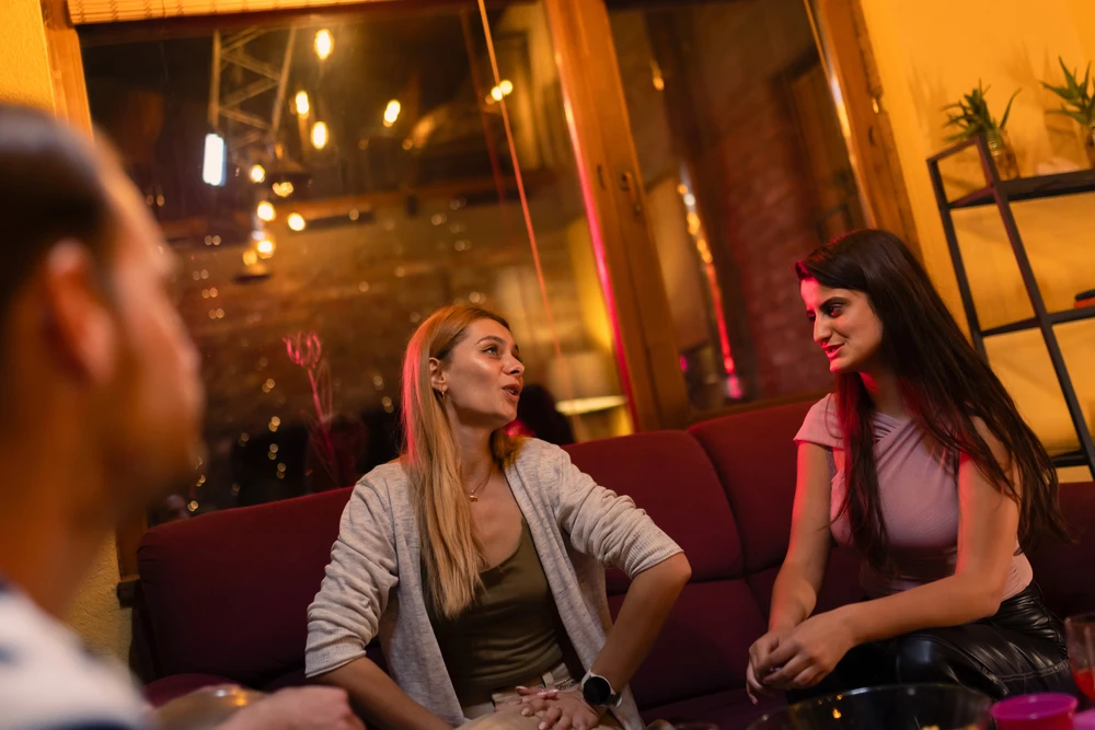 Jeunes en soirée qui se tutoient naturellement, ambiance détendue et conviviale typique des rencontres entre jeunes en France, photo choisie par monsieurdefrance.com.