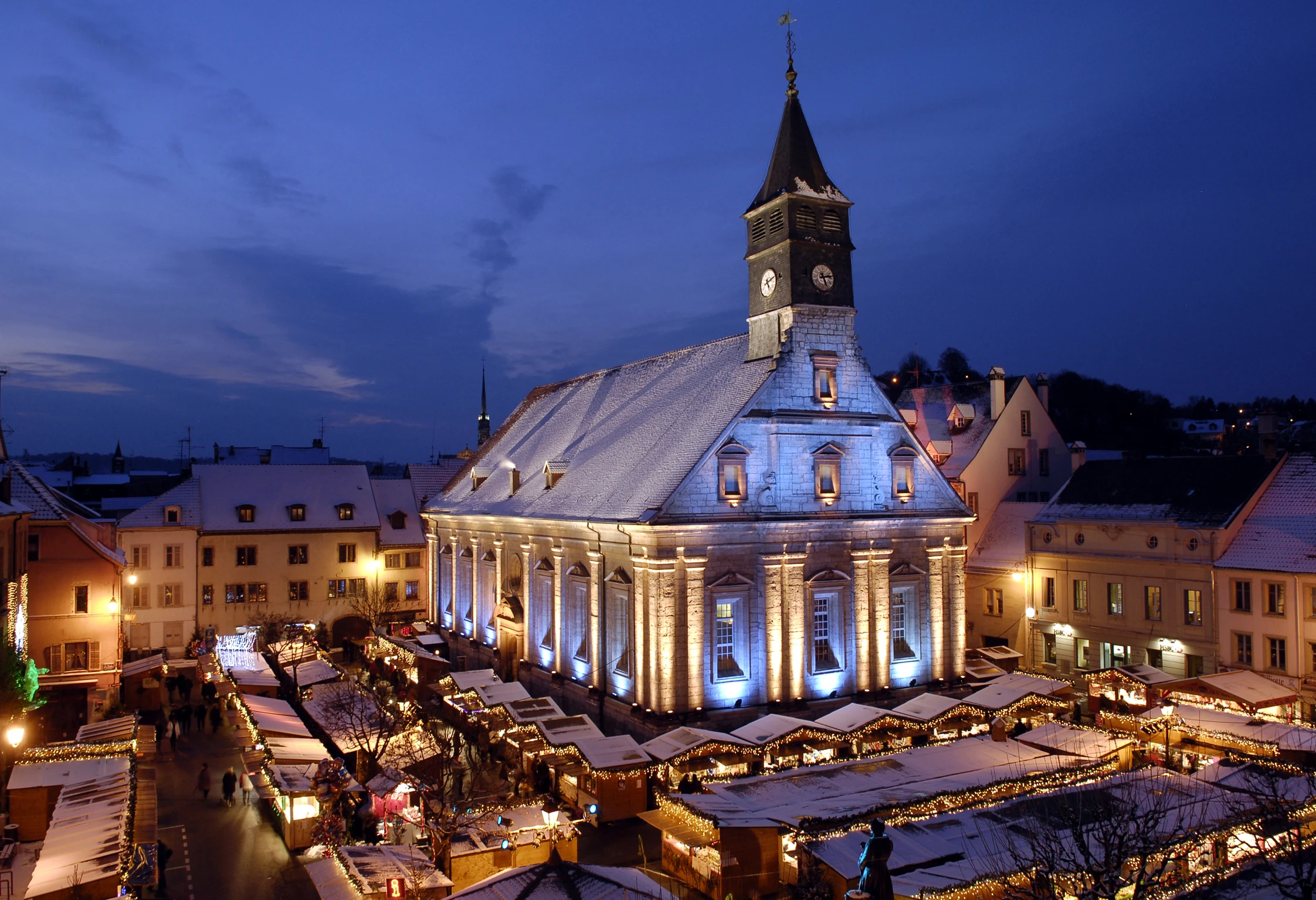Christmas market around the Saint-Martin temple in Montbéliard, the heart of the famous Christmas lights, combining crafts, delicacies, and winter magic. Photo published on monsieurdefrance.com.