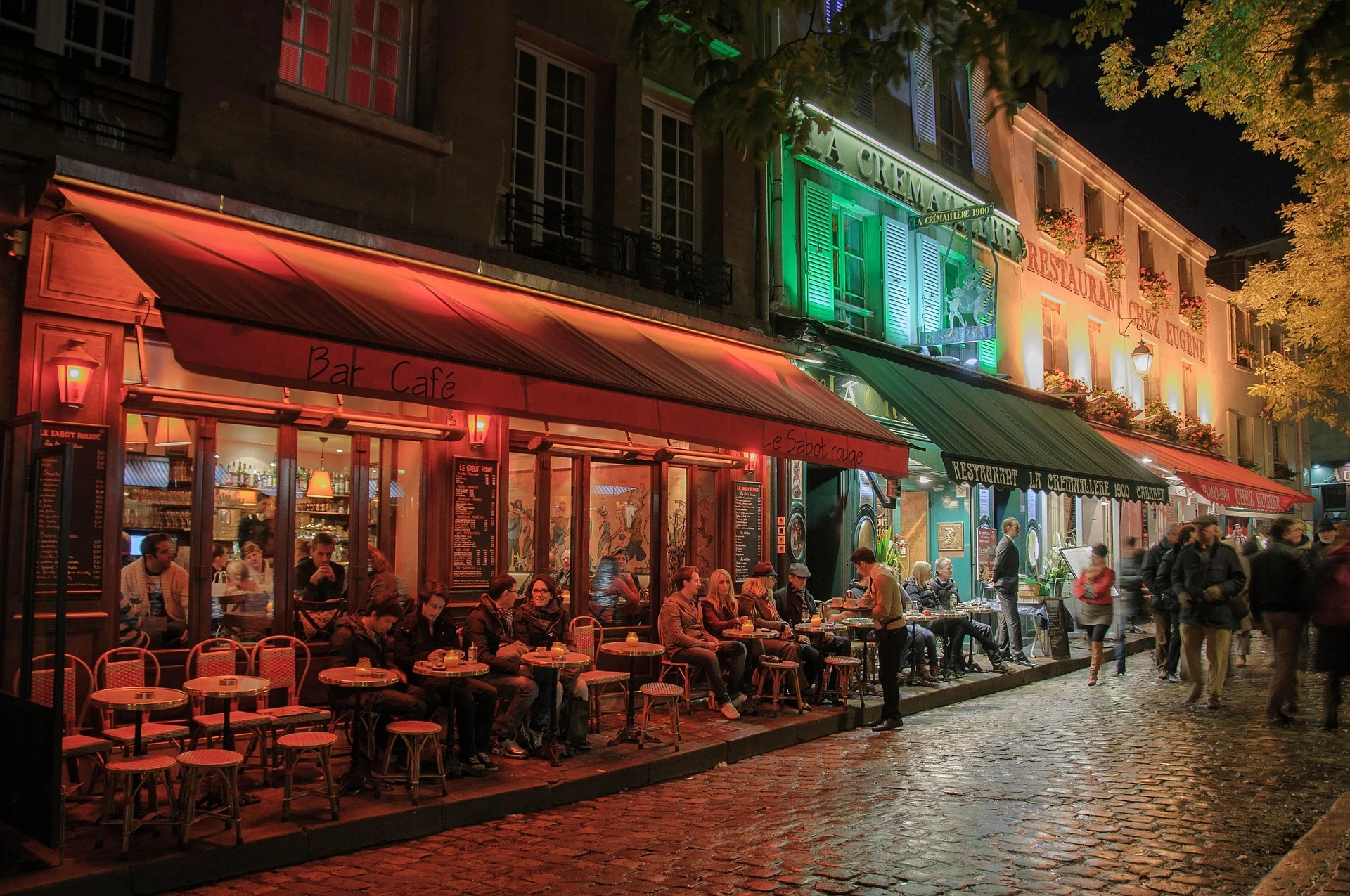 Restaurant parisien à Montmartre, de nuit, ambiance chaleureuse et ruelles illuminées, photo choisie par monsieurdefrance.com.