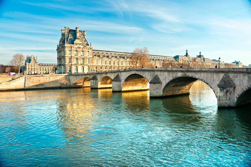 The Louvre as seen from the Seine with the Quai de la mégisserie at its feet/ Photo masterlu via depositphotos.